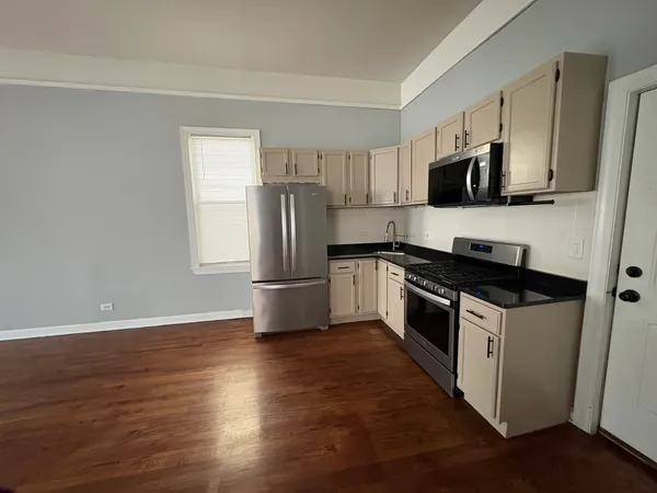a kitchen with stainless steel appliances a sink a stove a microwave and cabinetry