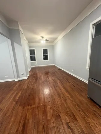 a view of empty room with wooden floor