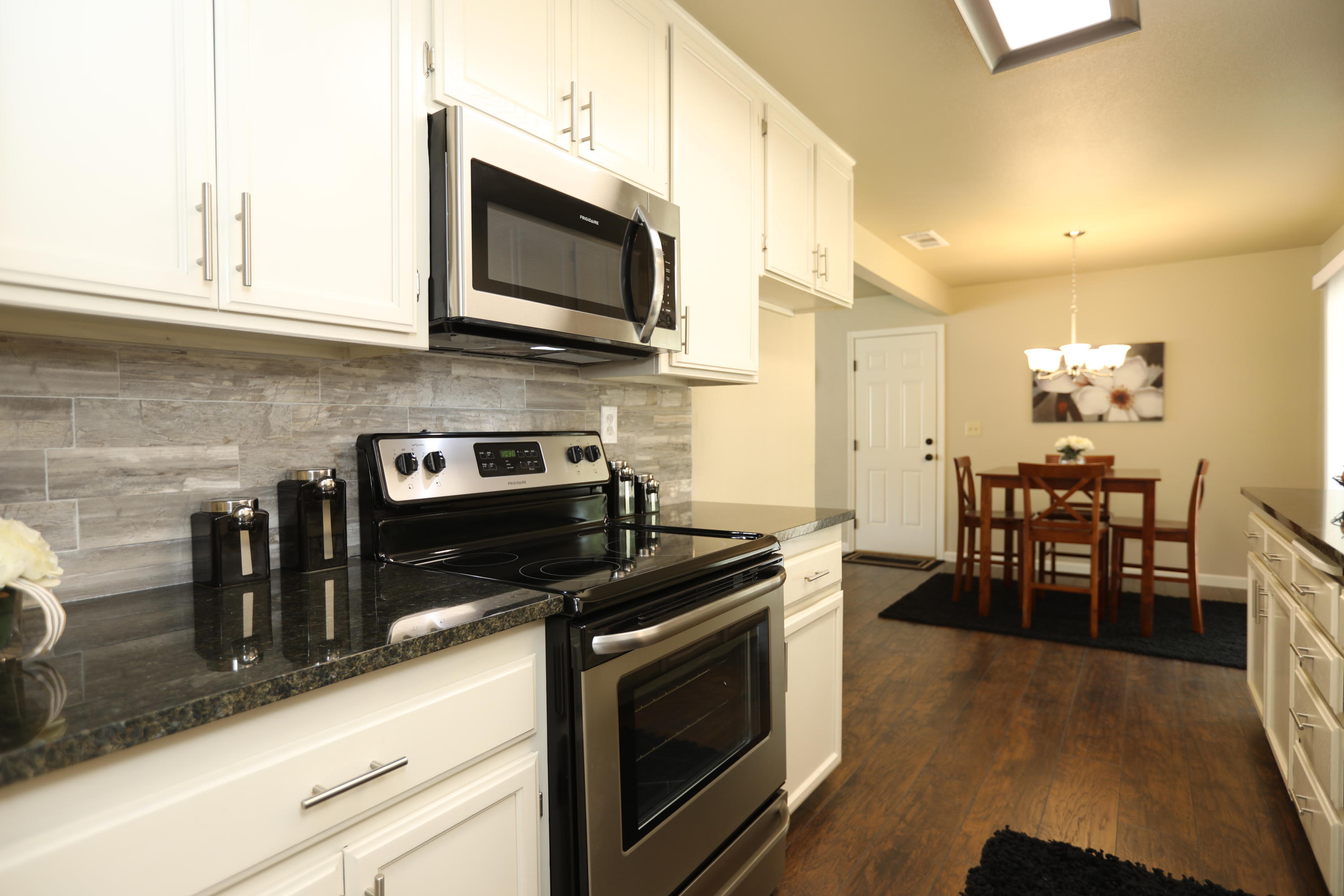 6560 Riverside Drive Redding, CA 96001 - Photo 4 of 15 a kitchen with stainless steel appliances a stove a sink a microwave and cabinets