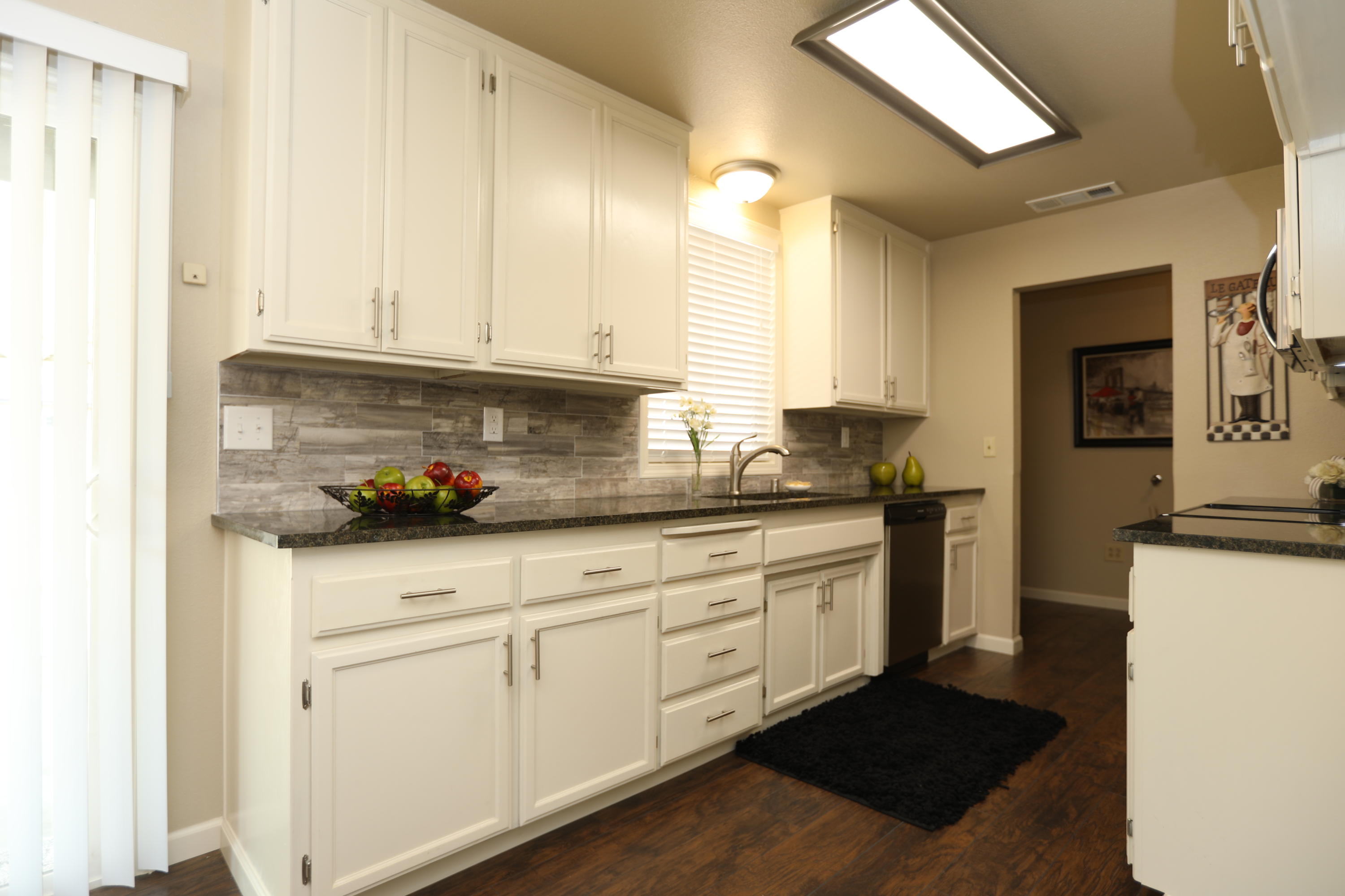 6560 Riverside Drive Redding, CA 96001 - Photo 5 of 15 a kitchen with granite countertop white cabinets and white appliances