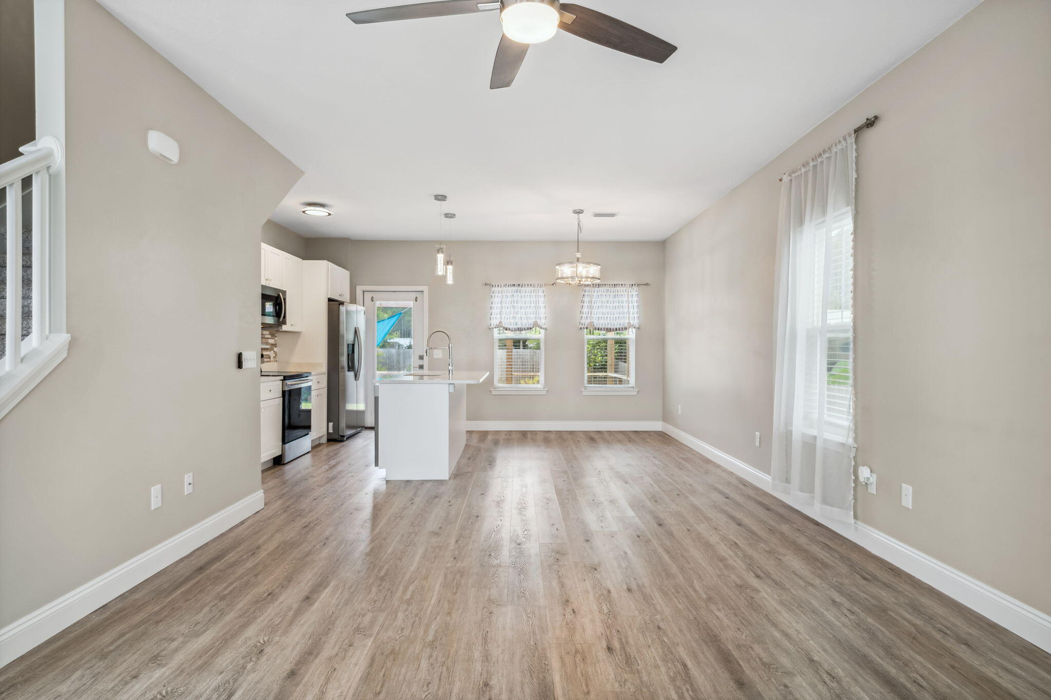 275 Indian Woman Road Santa Rosa Beach, FL 32459 - Photo 12 of 41 an empty room with wooden floor kitchen view and windows