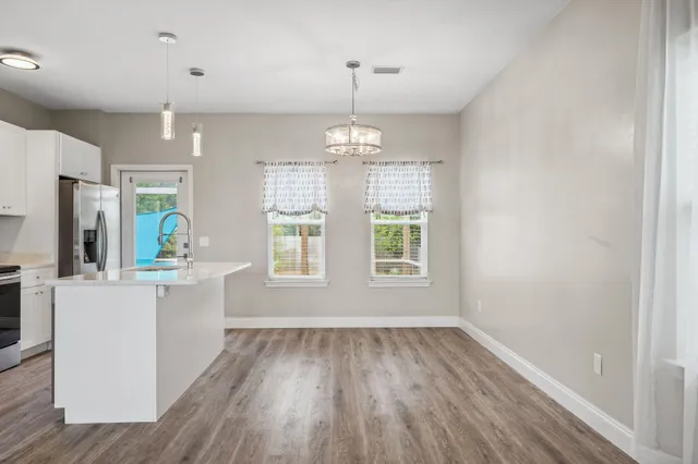 an empty room with wooden floor and windows