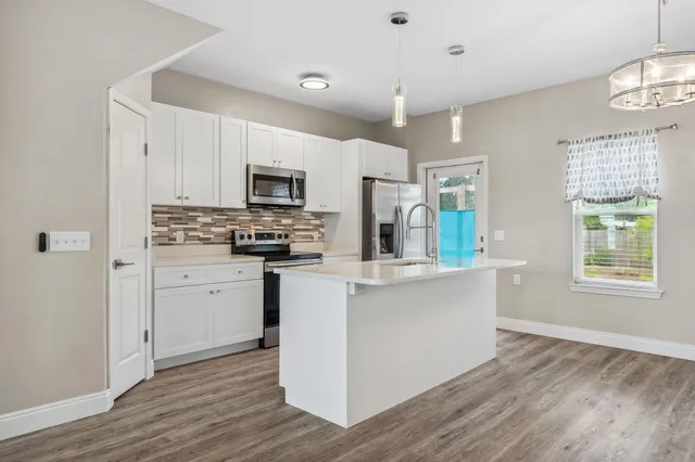 a kitchen with stainless steel appliances a refrigerator sink and microwave