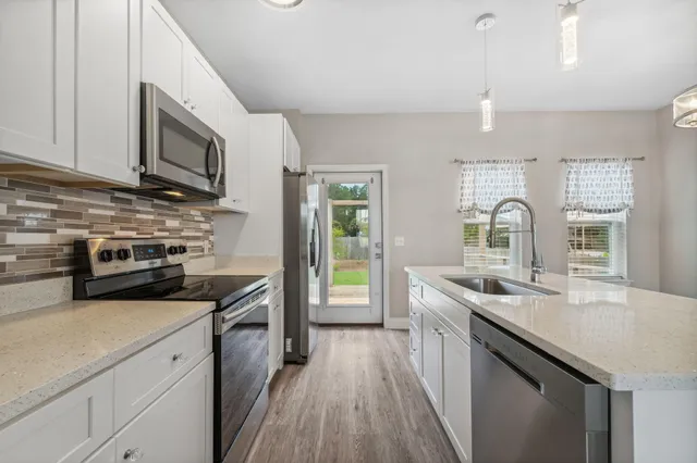 a kitchen with stainless steel appliances granite countertop a sink stove microwave and cabinets