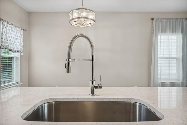 a kitchen with a sink and chandelier