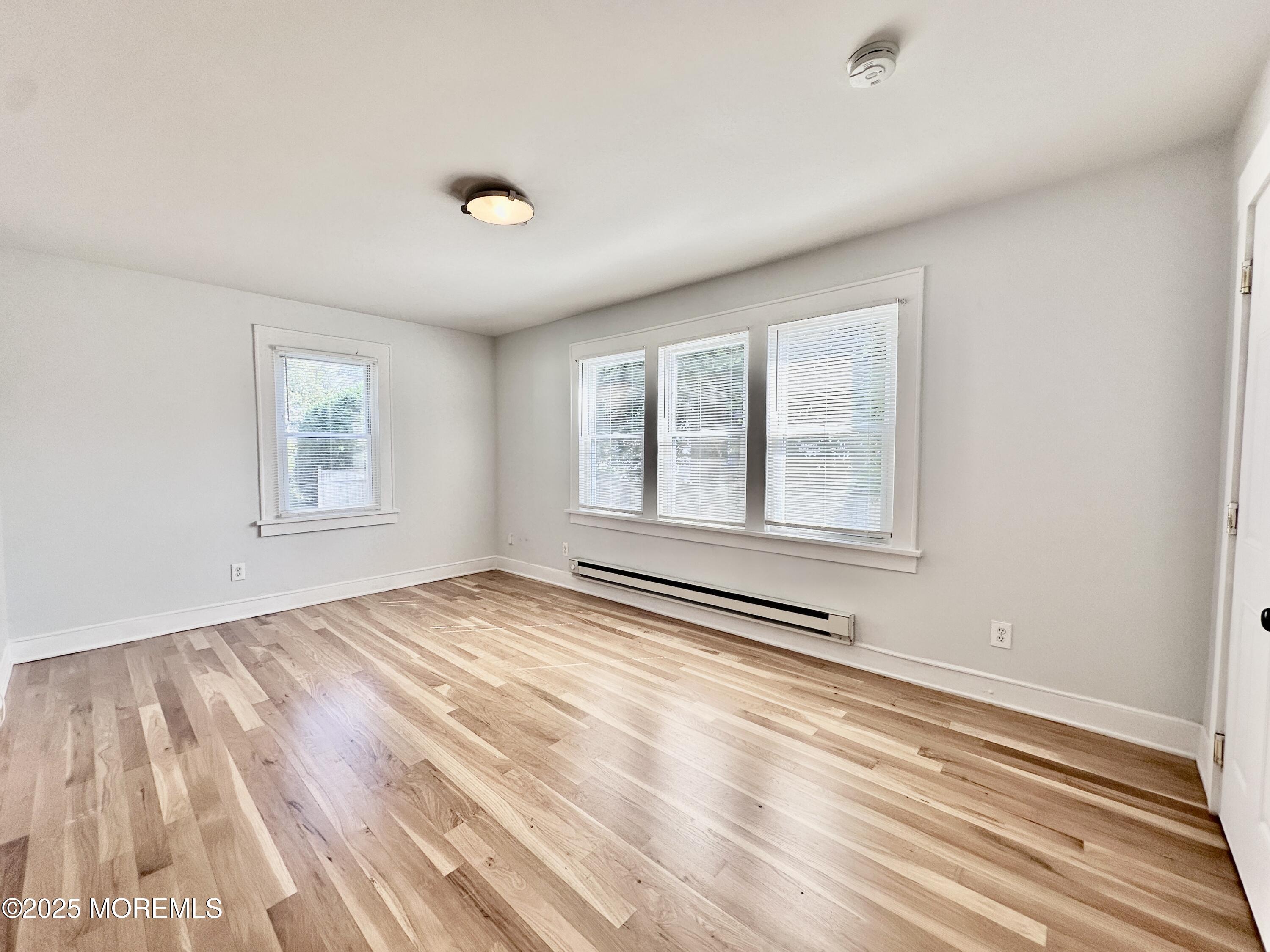 1004 5th Avenue, Unit 1N Asbury Park, NJ 07712 - Photo 3 of 14 a view of empty room with wooden floor and fan