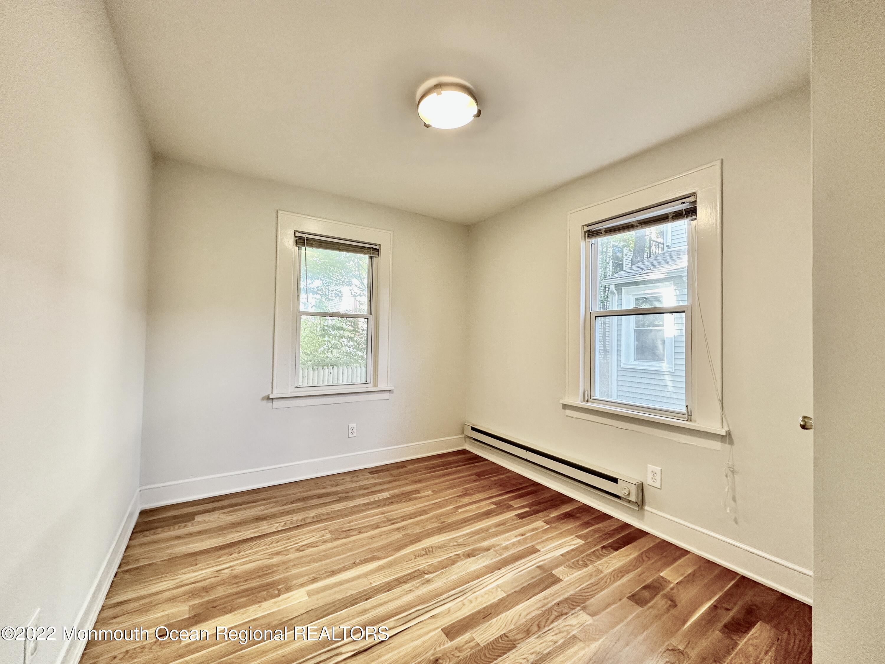 1004 5th Avenue, Unit 1N Asbury Park, NJ 07712 - Photo 6 of 14 a view of an empty room with wooden floor and a window