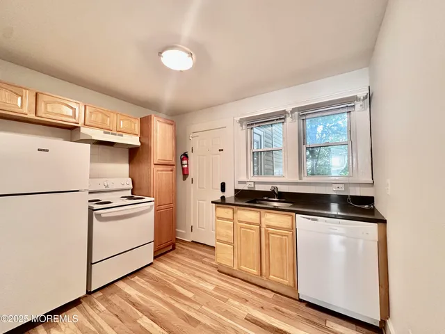 a kitchen with granite countertop white cabinets and white appliances