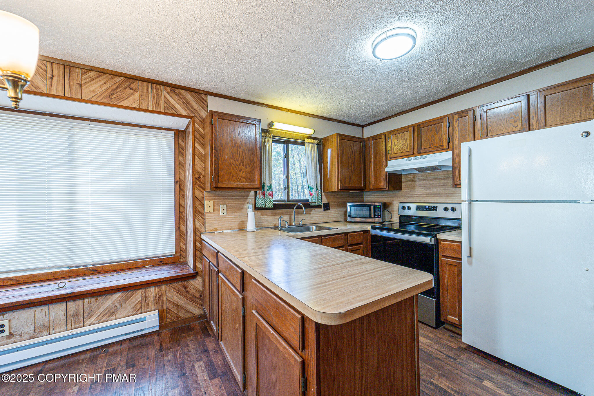 1562 Oak Lane Bushkill, PA 18324 - Photo 10 of 27 a kitchen with a refrigerator a stove and a sink with wooden floor