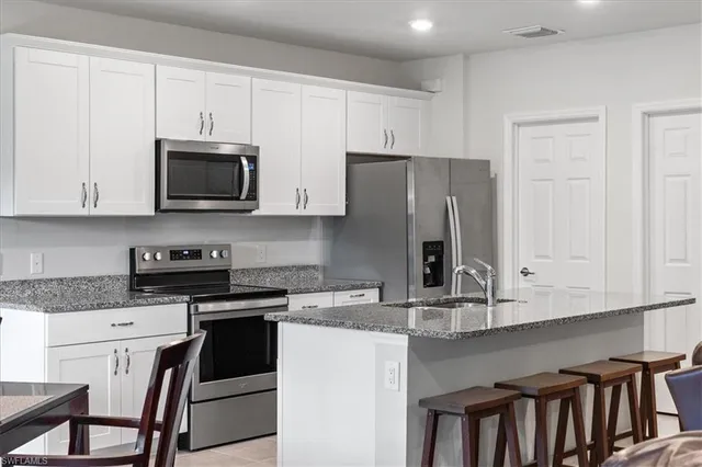 a kitchen with stainless steel appliances granite countertop a stove a sink and a refrigerator