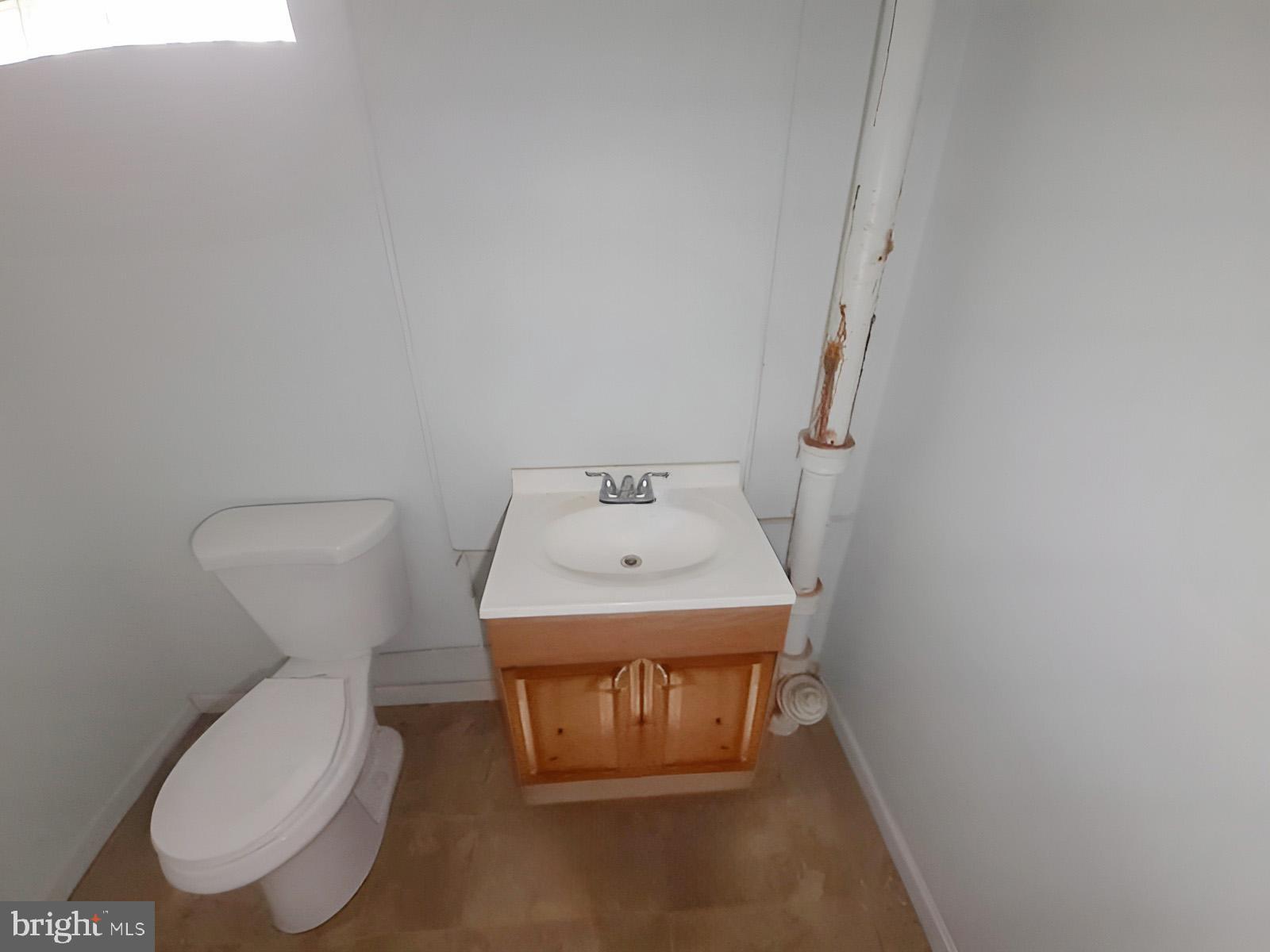 5619 Wesley Avenue Baltimore, MD 21207 - Photo 15 of 39 a bathroom with a toilet a sink and a mirror