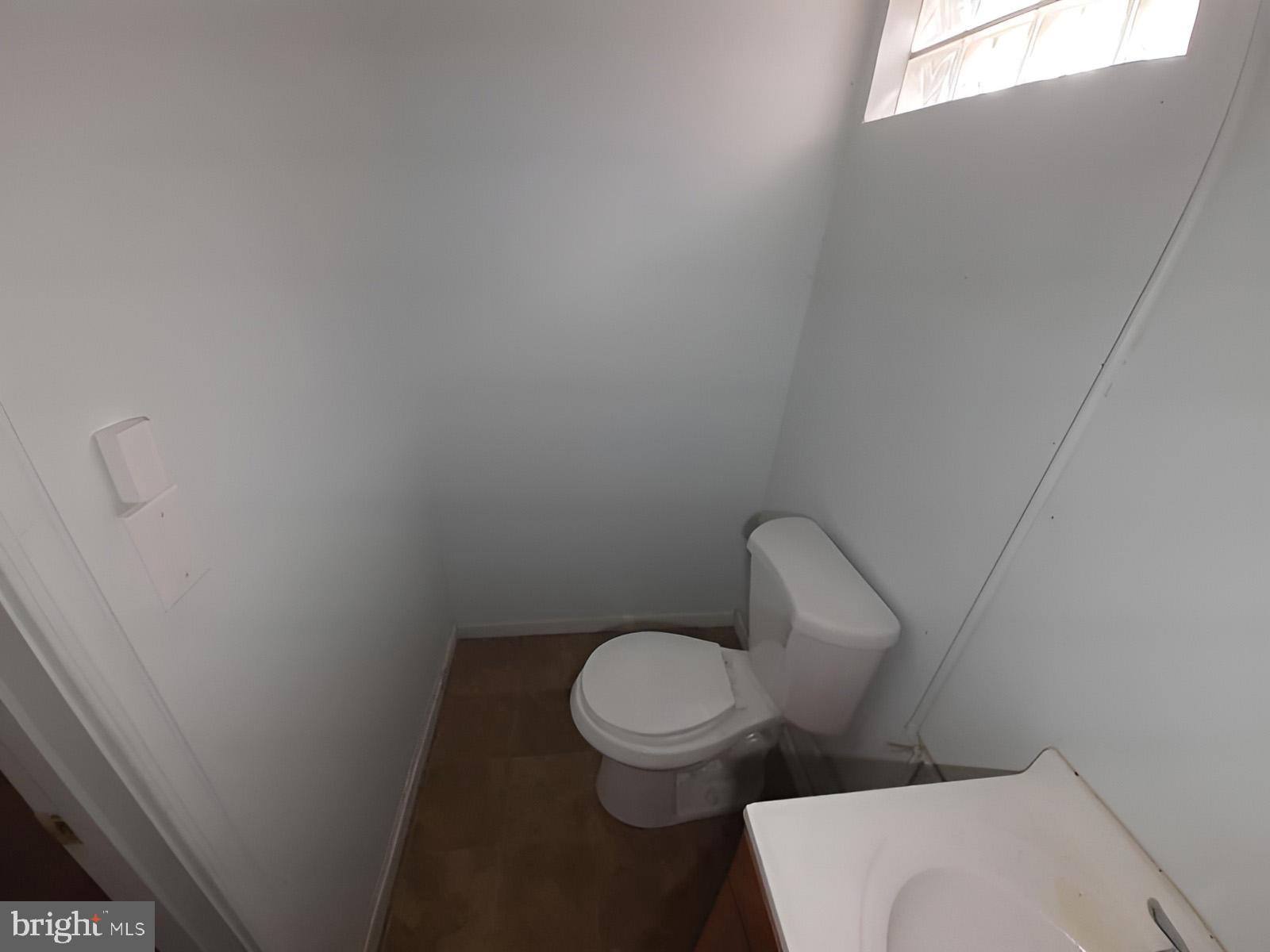 5619 Wesley Avenue Baltimore, MD 21207 - Photo 16 of 39 a white toilet sitting next to a small window