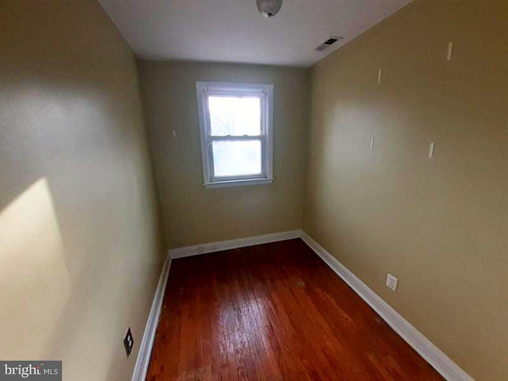 5619 Wesley Avenue Baltimore, MD 21207 - Photo 21 of 29 an empty room with wooden floor and windows