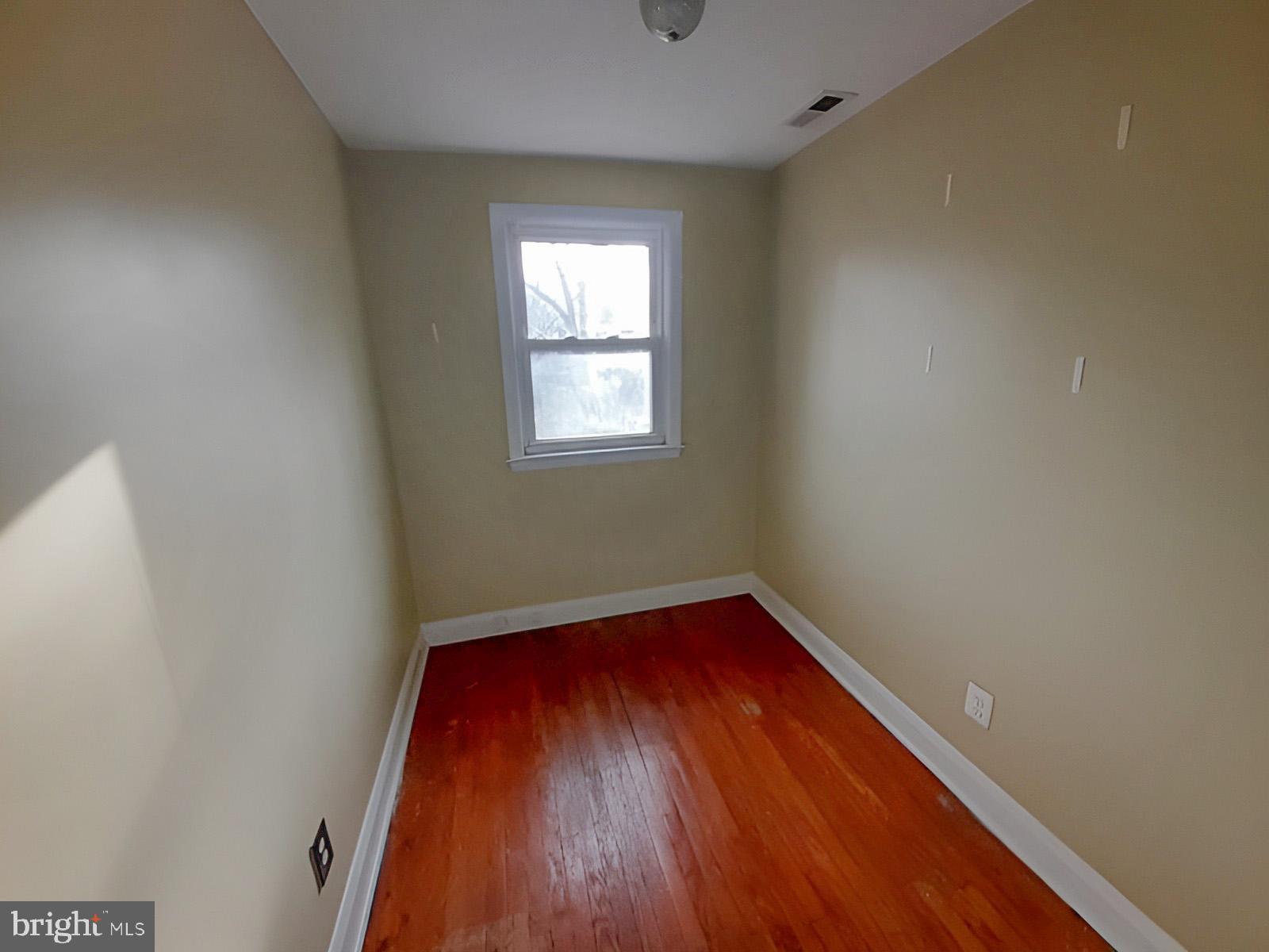 5619 Wesley Avenue Baltimore, MD 21207 - Photo 22 of 39 an empty room with a hardwood and a window