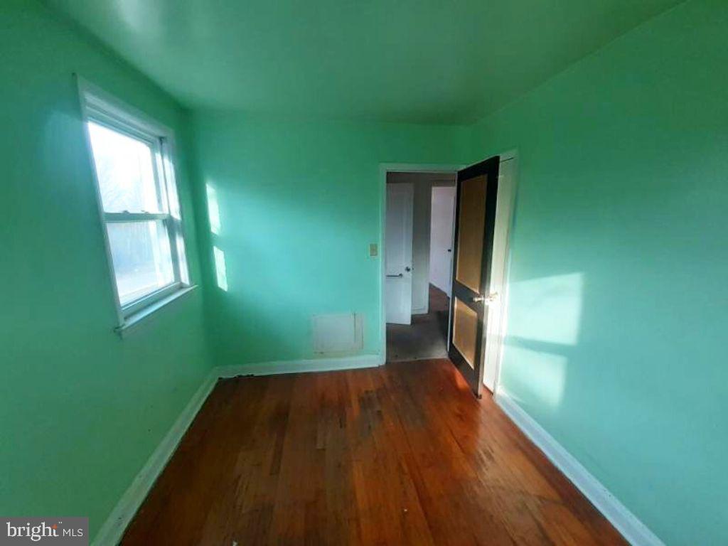 5619 Wesley Avenue Baltimore, MD 21207 - Photo 24 of 29 a view of a room with wooden floor and a window