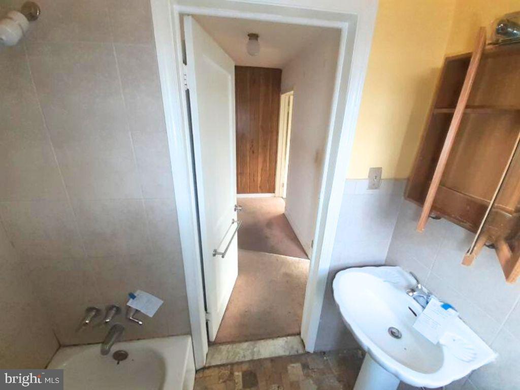 5619 Wesley Avenue Baltimore, MD 21207 - Photo 26 of 29 a bathroom with a sink and mirror with toilet