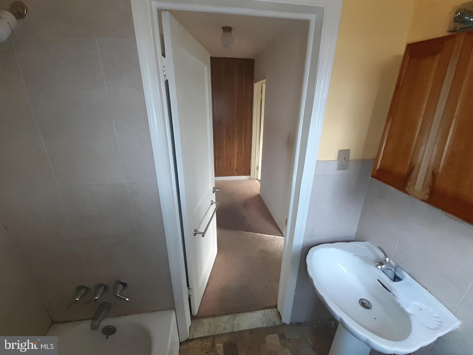 5619 Wesley Avenue Baltimore, MD 21207 - Photo 27 of 39 a bathroom with a sink and mirror
