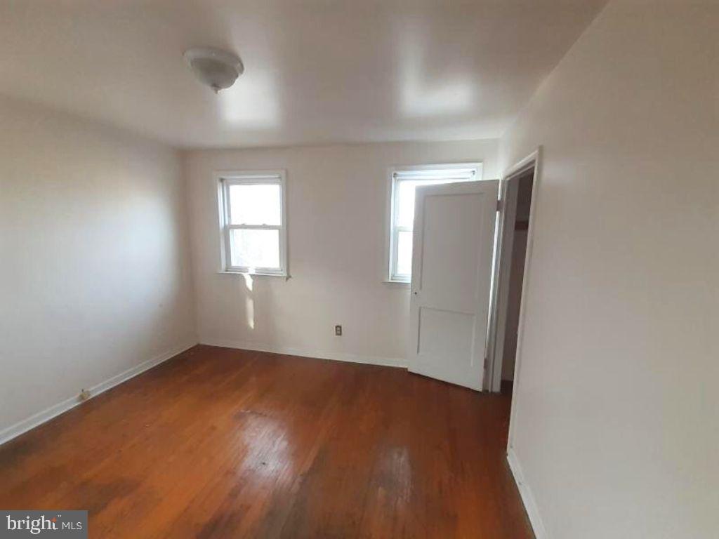5619 Wesley Avenue Baltimore, MD 21207 - Photo 28 of 29 an empty room with wooden floor and windows