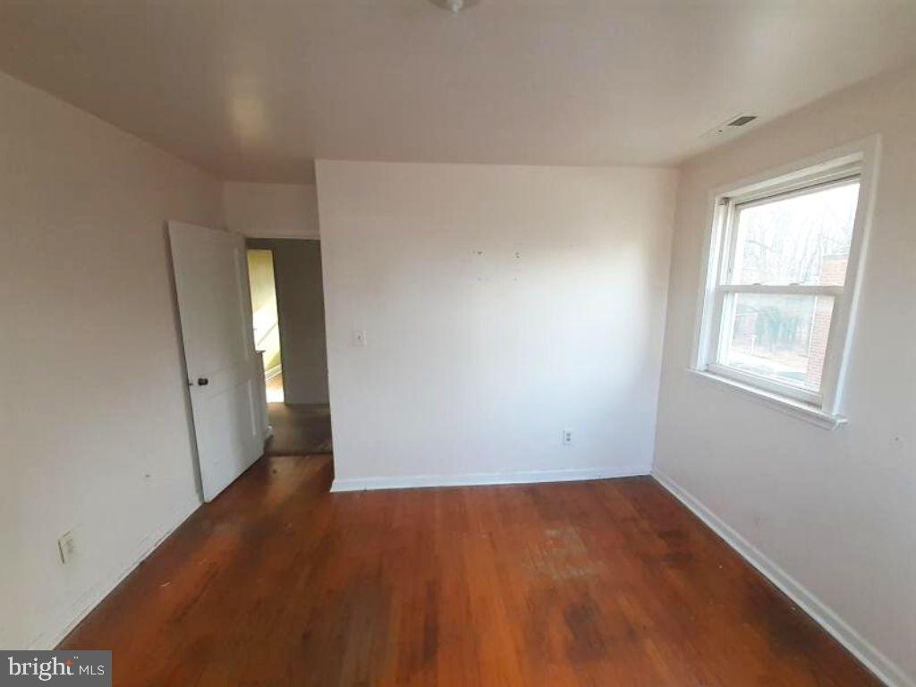 5619 Wesley Avenue Baltimore, MD 21207 - Photo 29 of 29 an empty room with wooden floor and windows