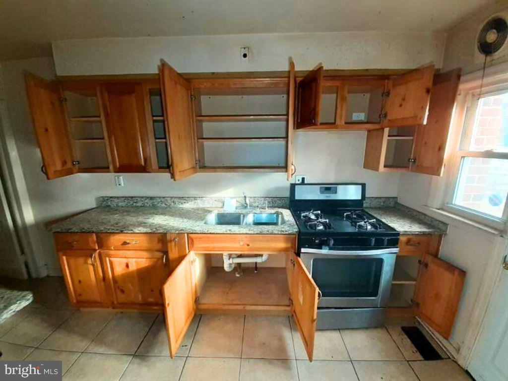 5619 Wesley Avenue Baltimore, MD 21207 - Photo 8 of 29 a kitchen with granite countertop a stove and a cabinets