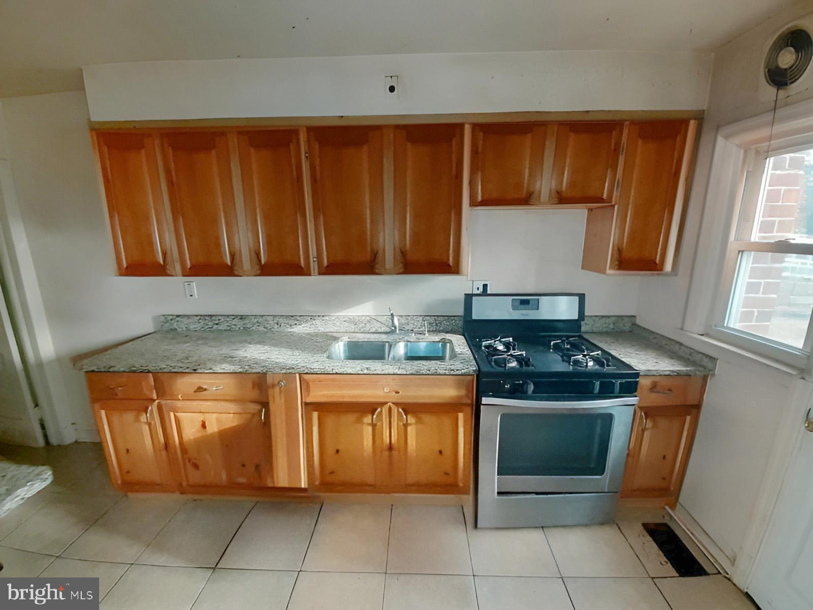 5619 Wesley Avenue Baltimore, MD 21207 - Photo 8 of 39 a kitchen with granite countertop a sink and a stove