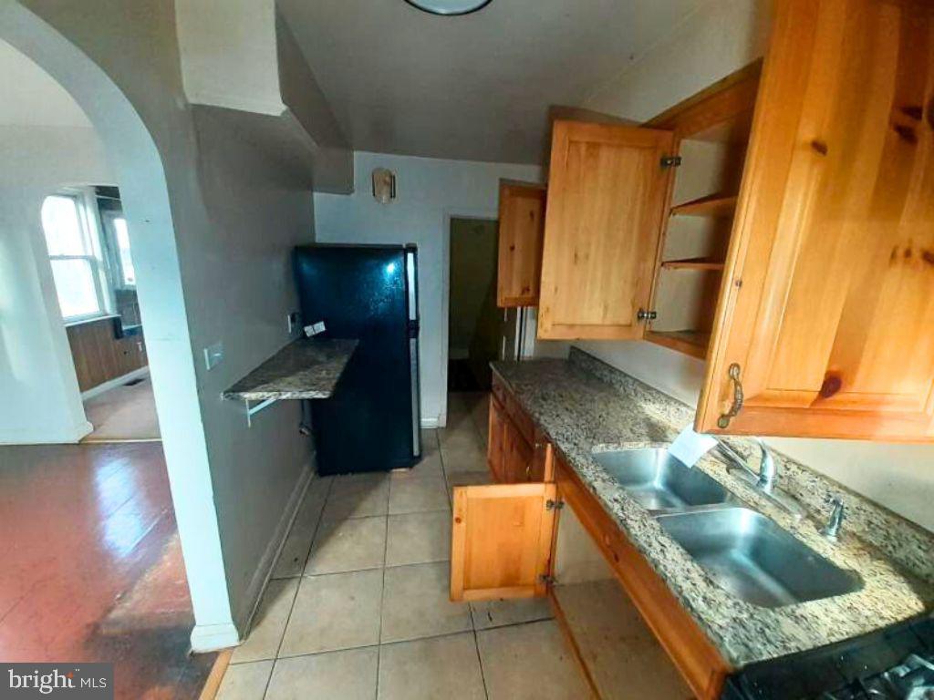 5619 Wesley Avenue Baltimore, MD 21207 - Photo 9 of 29 a kitchen with granite countertop a sink and a stove