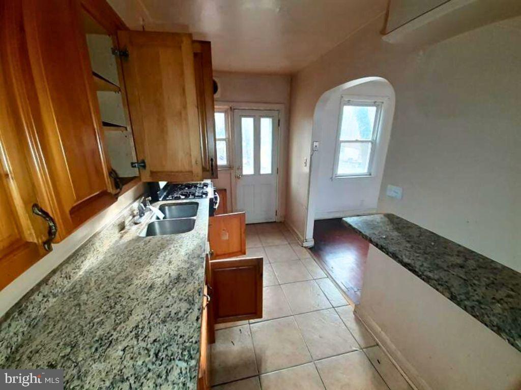 5619 Wesley Avenue Baltimore, MD 21207 - Photo 10 of 29 a kitchen with granite countertop a sink and a stove