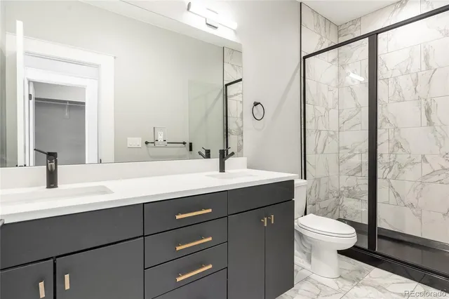 a bathroom with a granite countertop sink toilet a mirror and shower