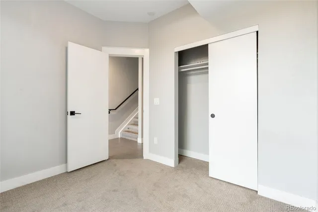a view of an empty room with stairs and a ceiling fan