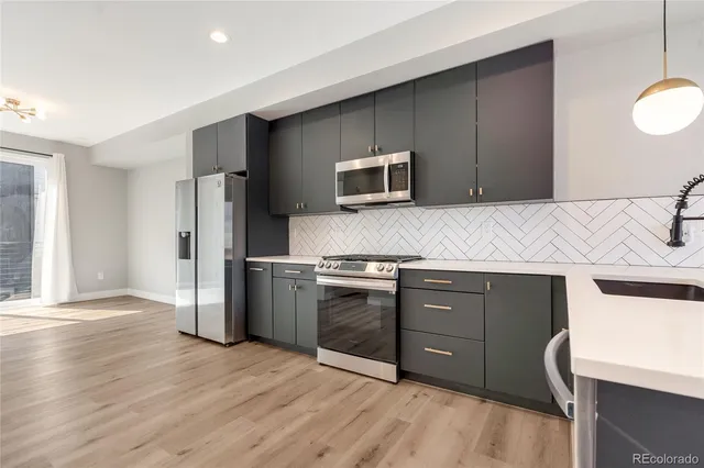 a kitchen with stainless steel appliances granite countertop a stove a microwave and a refrigerator