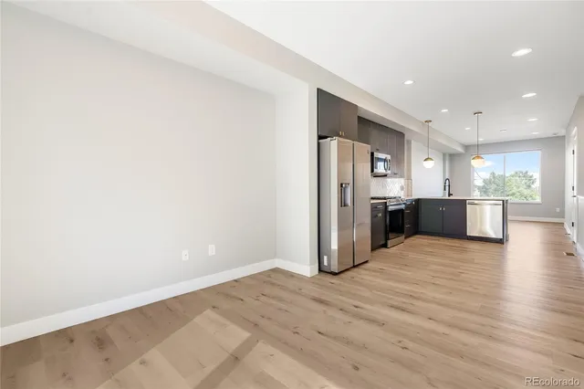 a view of a kitchen with a sink and a refrigerator