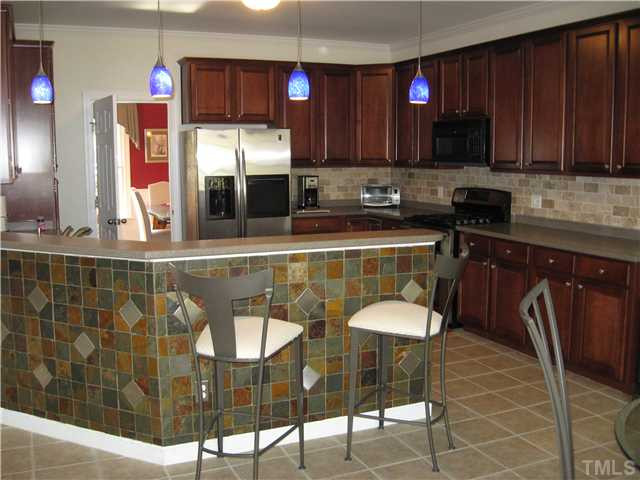 1008 Clark Ridge Court Raleigh, NC 27613 - Photo 5 of 15 Beautiful gourmet kitchen with tile front counter, tile backspash, solid surface countertops, some stainless steel appliances, double oven, gas stove, microwave, gorgeous cherry cabinets and two pantries. Kitchen
