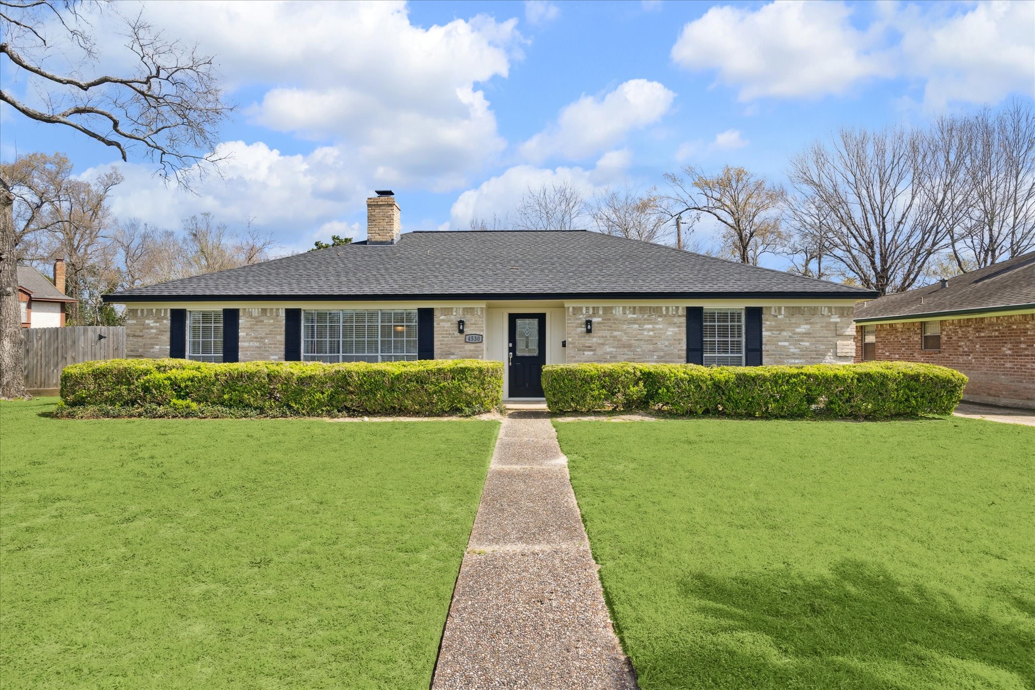 a front view of a house with yard and green space