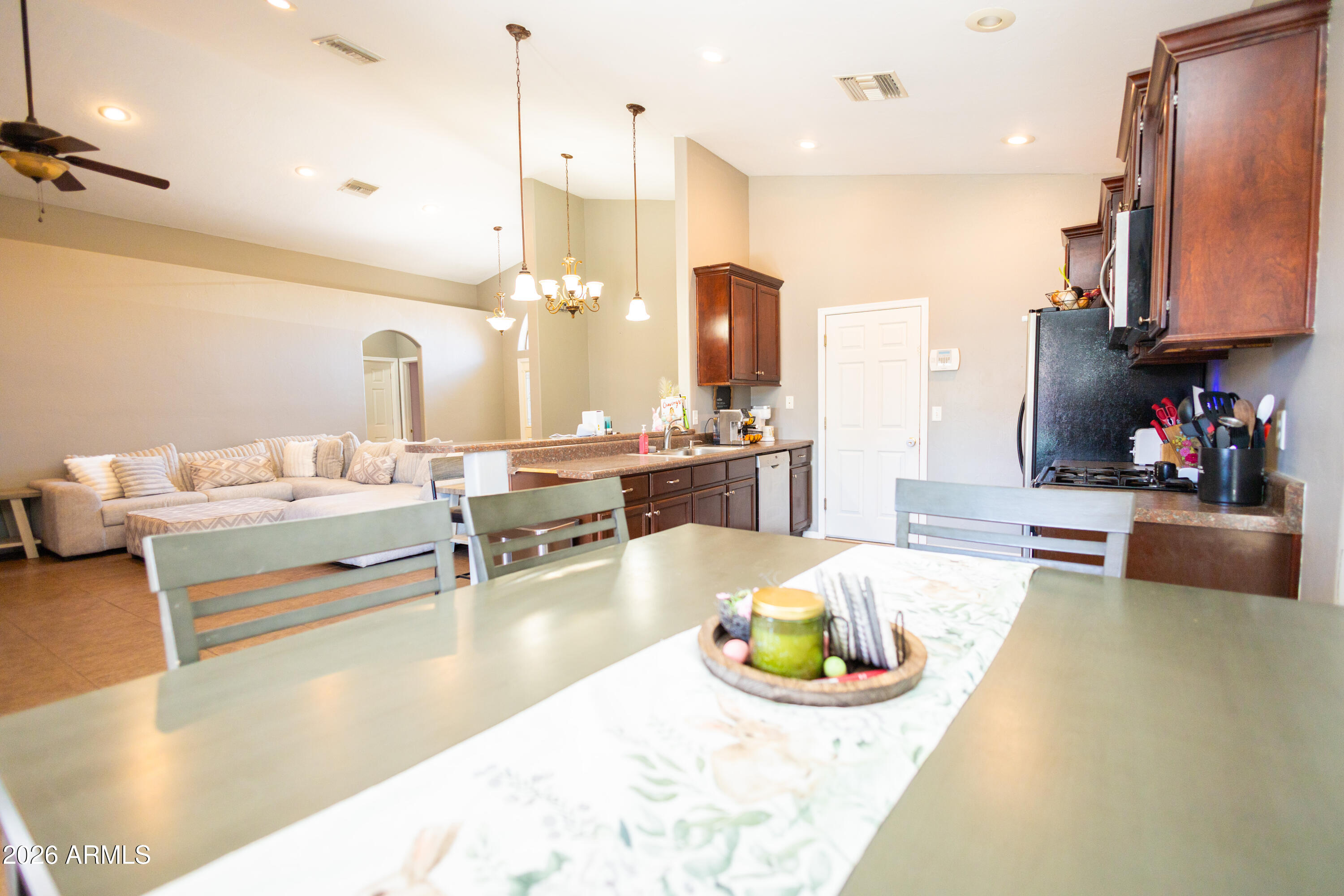2705 East 7th Street Douglas, AZ 85607 - Photo 6 of 19 a large kitchen with kitchen island stainless steel appliances a stove a sink dishwasher a dining table and chairs with wooden floor