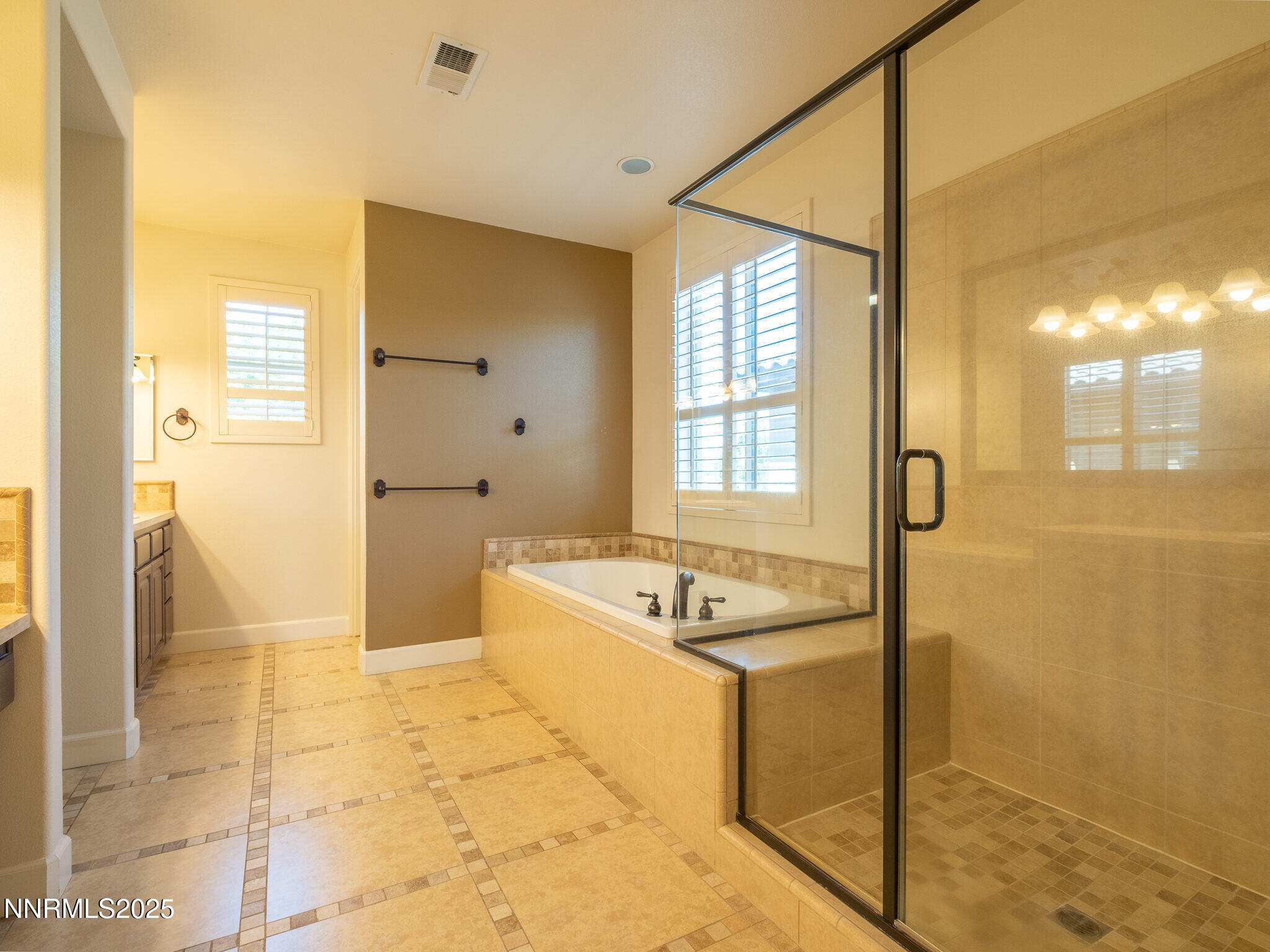 3985 San Donato Loop Reno, NV 89519 - Photo 26 of 29 a bathroom with a granite countertop sink a mirror and a bathtub