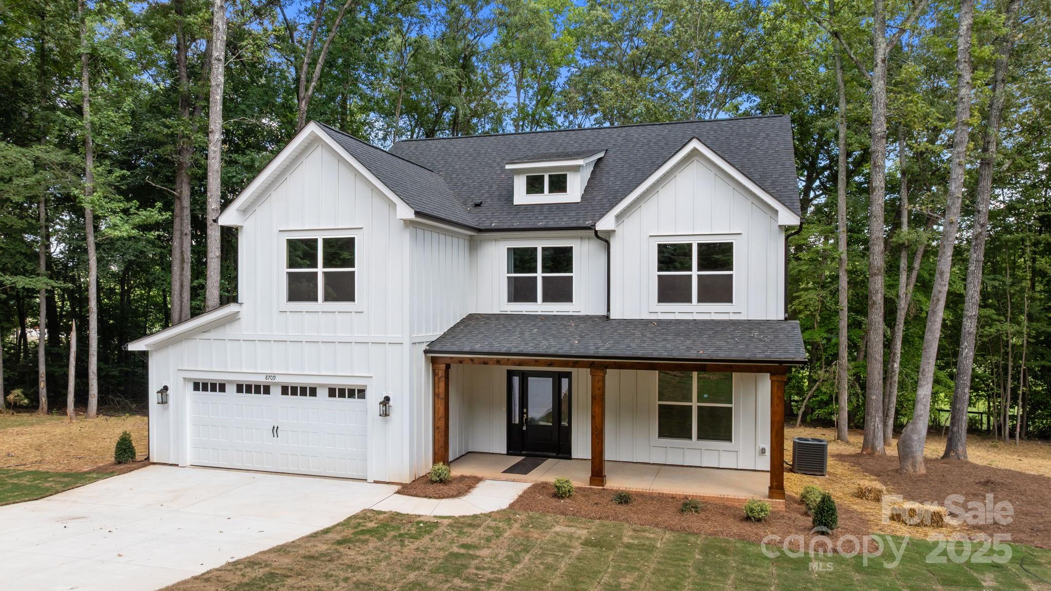 a view of a white house with large windows and a small yard