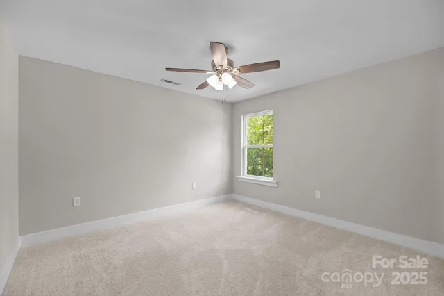 an empty room with a window and a ceiling fan