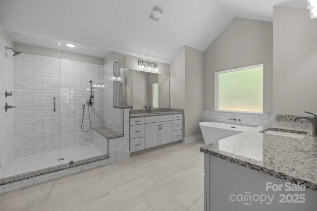 a bathroom with a granite countertop sink mirror and shower