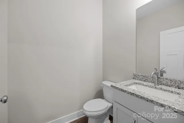 a bathroom with a granite countertop sink toilet and a mirror