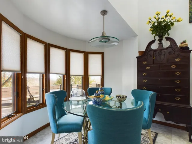 a dining room with wooden floor windows and outdoor space