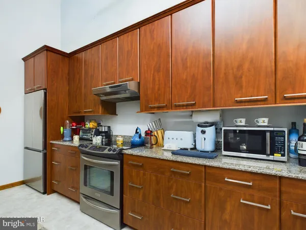 a kitchen with stainless steel appliances granite countertop a refrigerator stove and sink