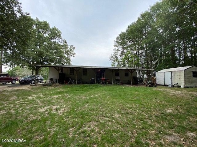 1155 Macedonia Church Road Cochran, GA 31014 - Photo 22 of 22 a view of a backyard with table and chairs plants and large trees