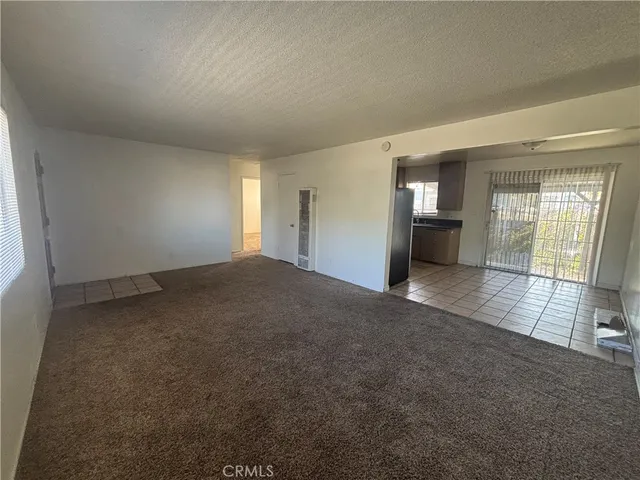 en empty room with windows and fireplace