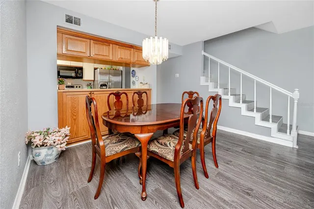 a dining room with furniture a chandelier and wooden floor