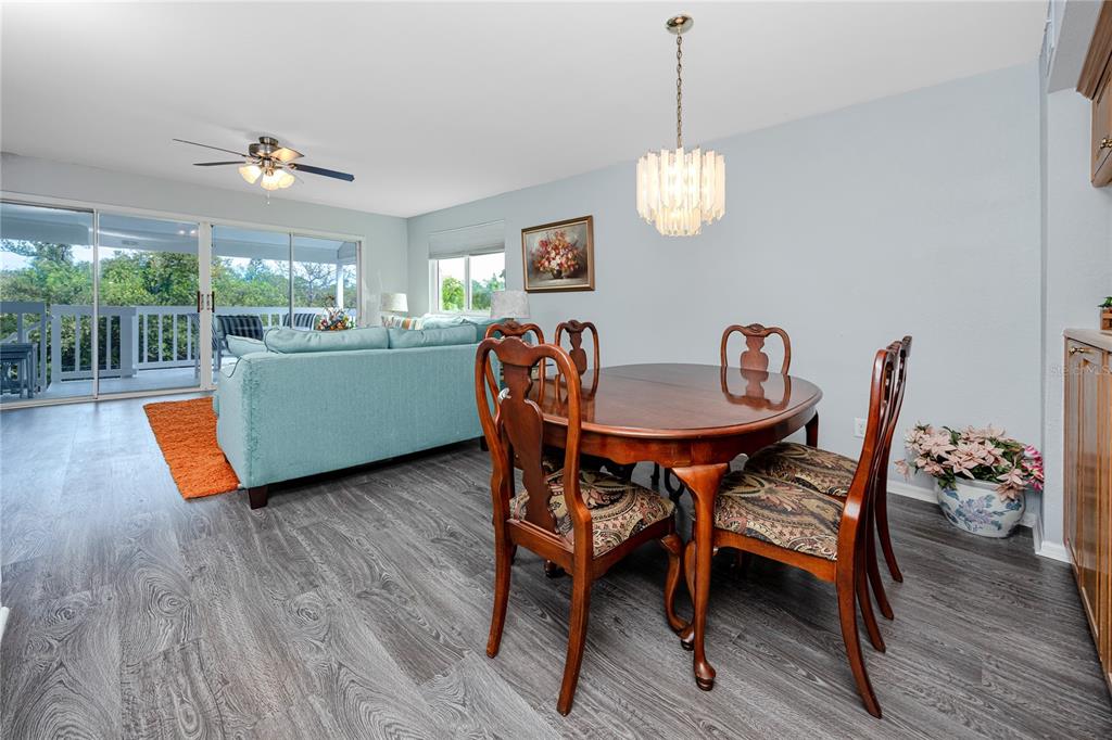 816 Hidden Harbour Drive Indian Rocks Beach, FL 33785 - Photo 10 of 58 a dining room with furniture a chandelier and wooden floor