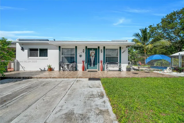 a view of a house with backyard porch and a small yard