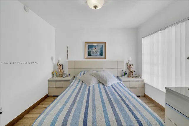 a view of bedroom with wooden floor and bed