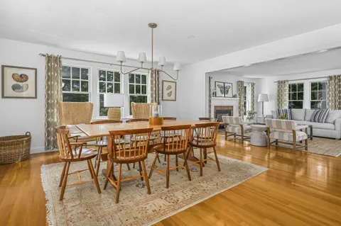 a dining room with furniture a chandelier and wooden floor