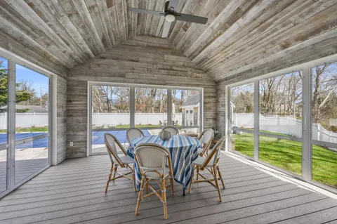 a view of a dining room with furniture large windows and wooden floor