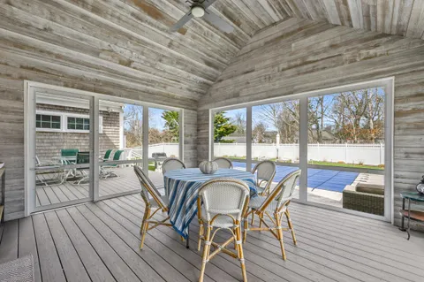a dining room with furniture large windows and wooden floor